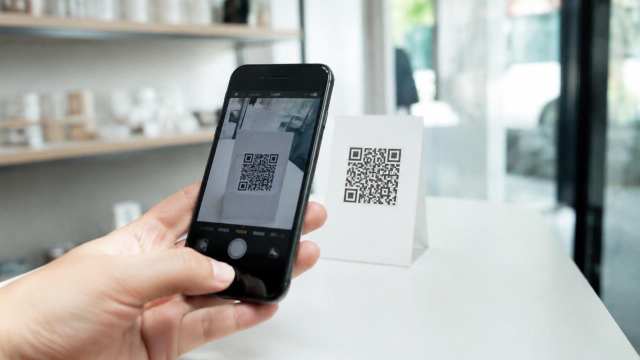Phone camera scanning a QR code on a table stand